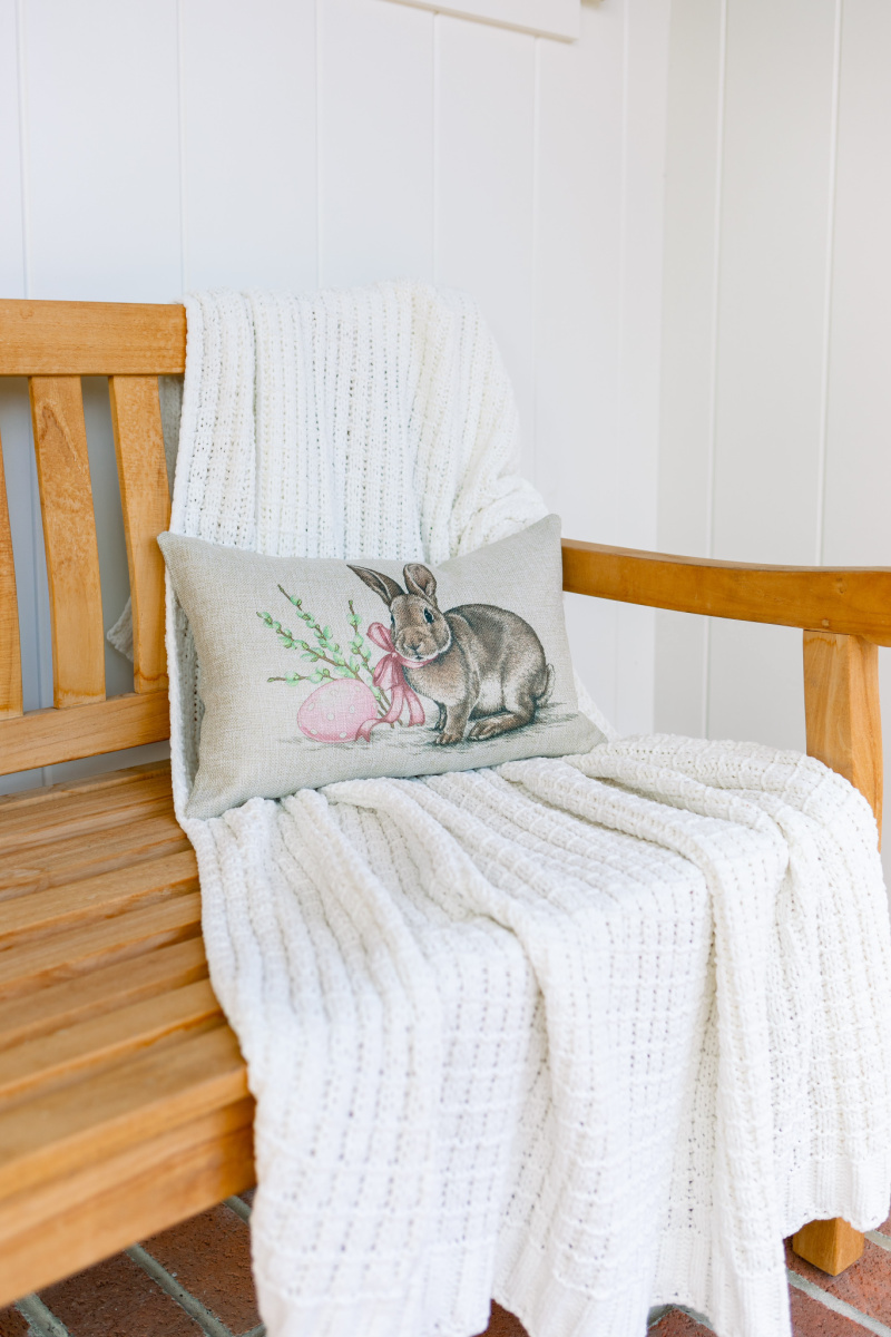 Bunny lumbar pillow on teak bench