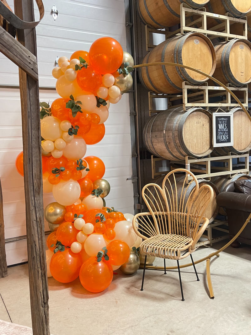 Orange balloon garland and fan back chair