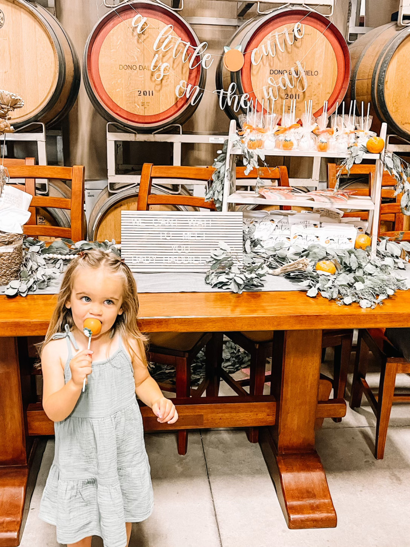 Baby shower table and little girl eating cake pop