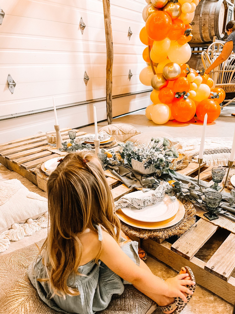Little girl sitting on the floor at picnic table