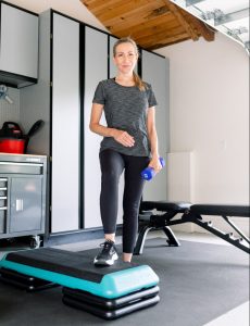 Woman holding hand weight in garage gym