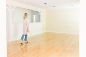 Woman standing in empty room before renovation