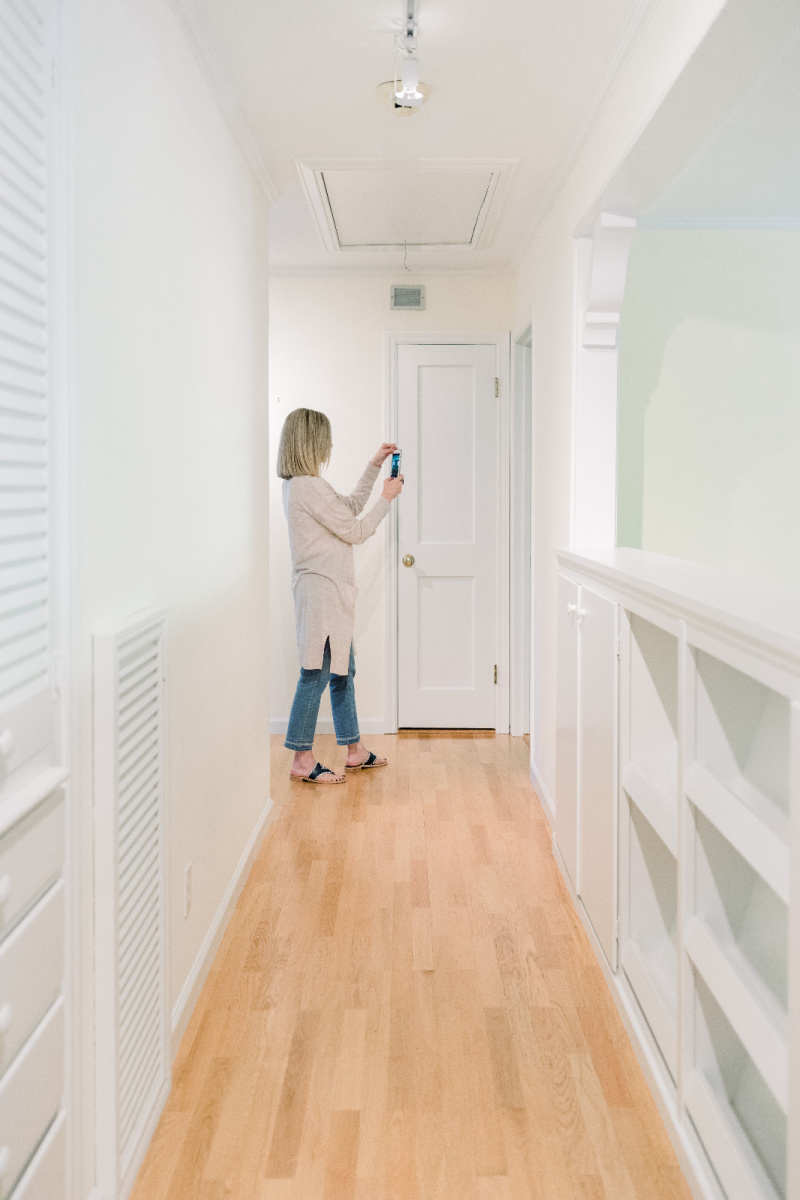 Woman at end of hallway taking pictures