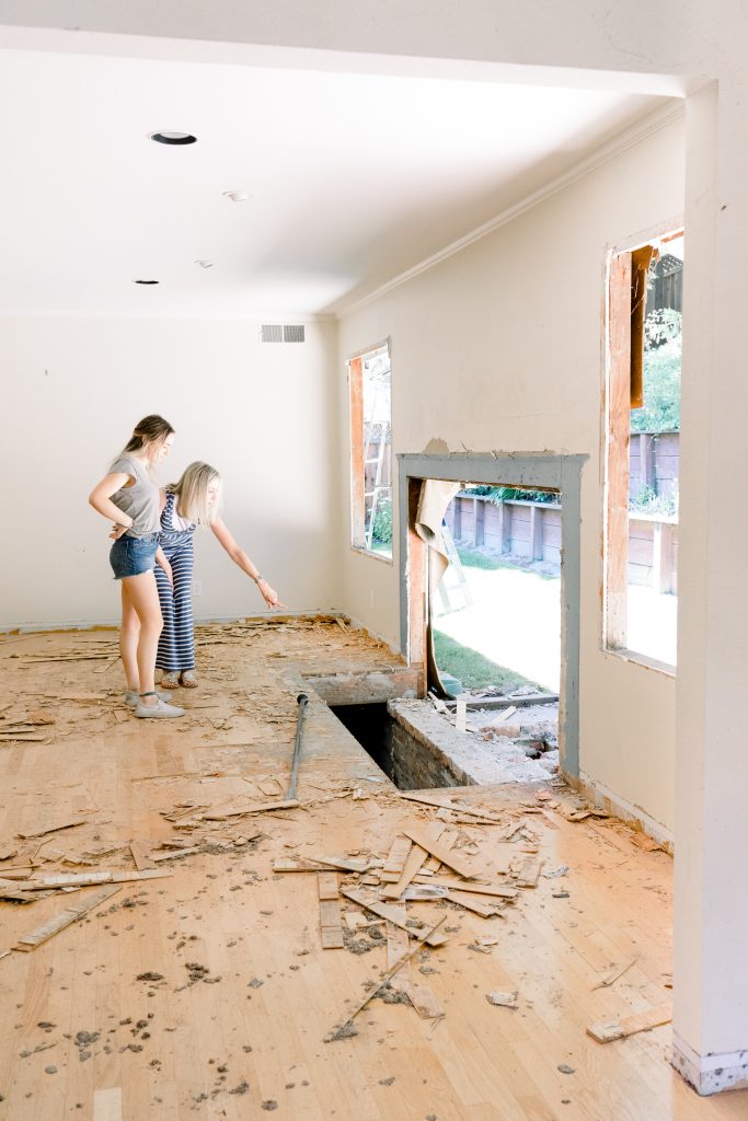 Two women looking at demolished fireplace