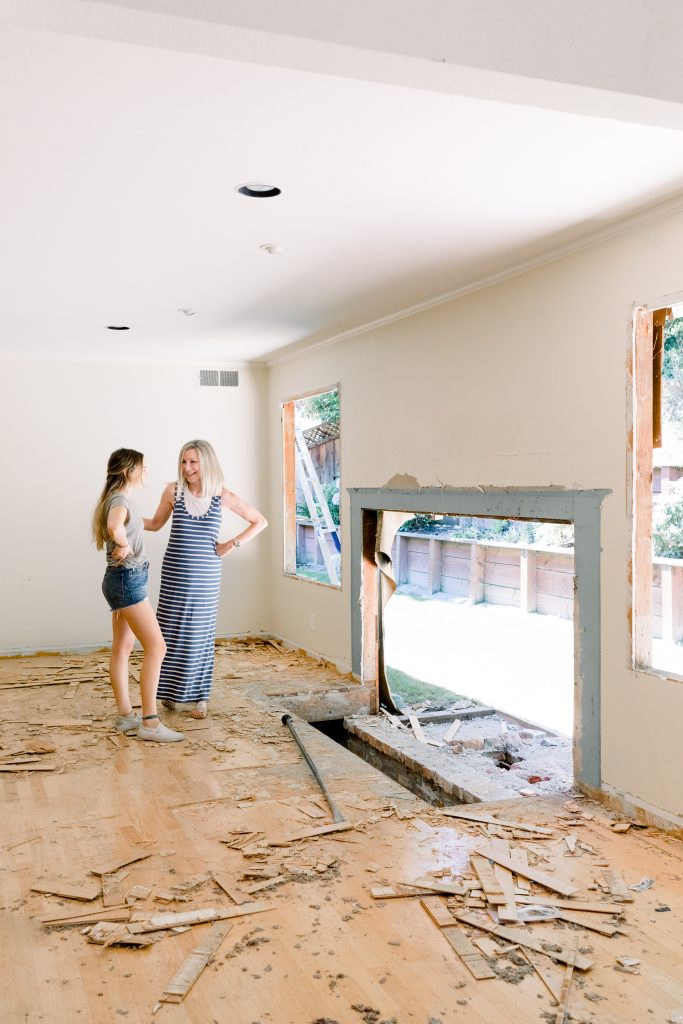 Two woman looking at demolished fireplace
