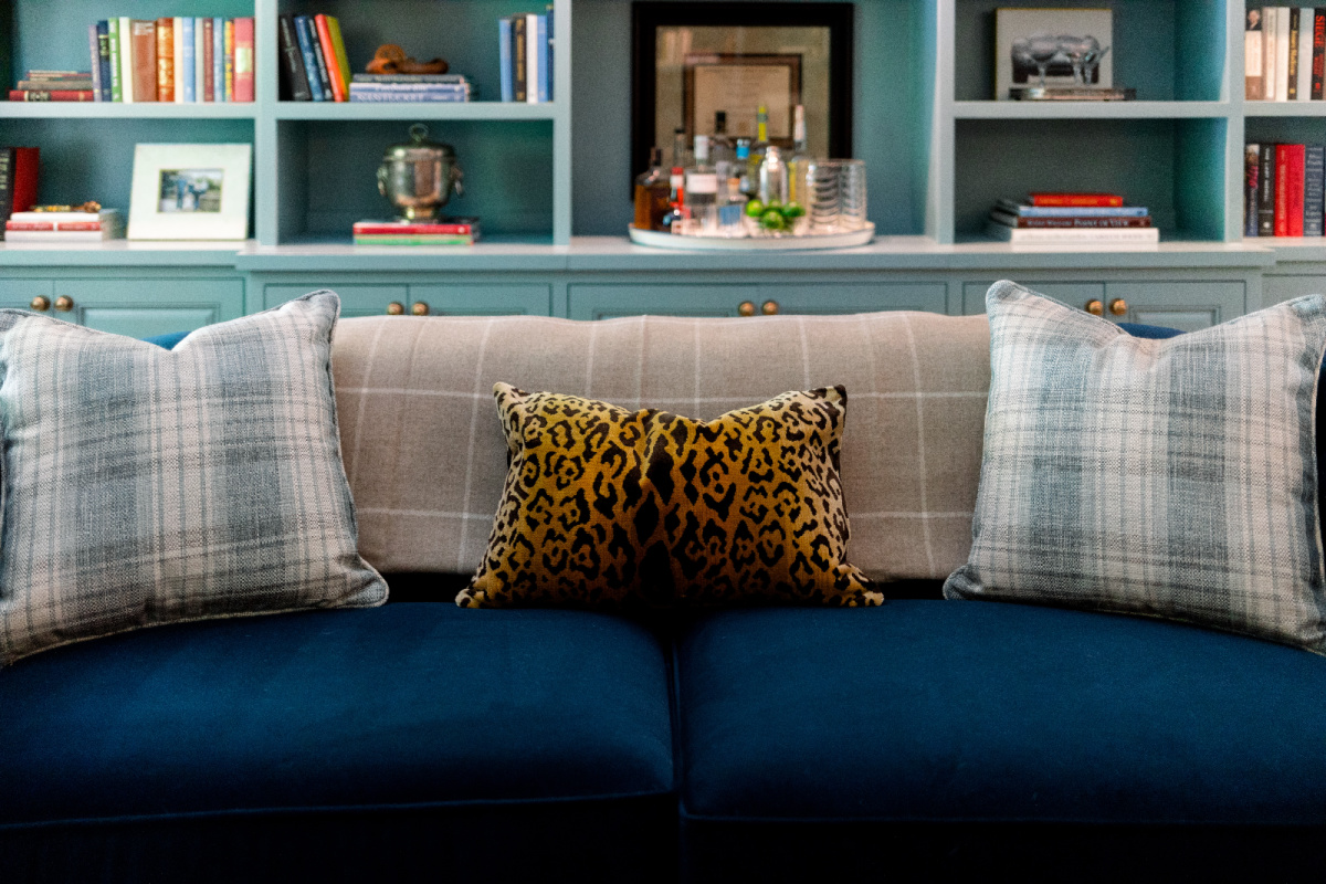 Blue velvet sofa with leopard print pillow