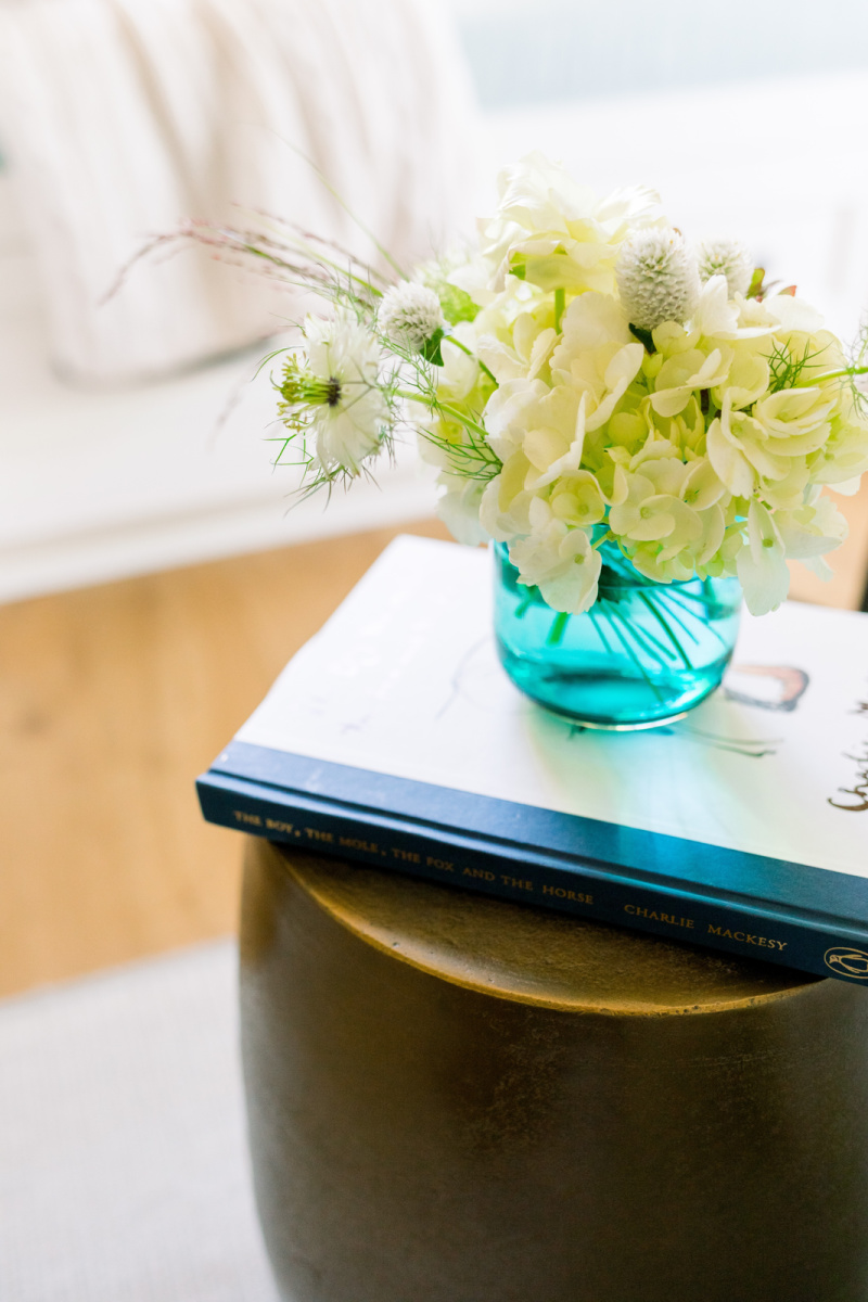 Book and floral arrangement on side table vignette
