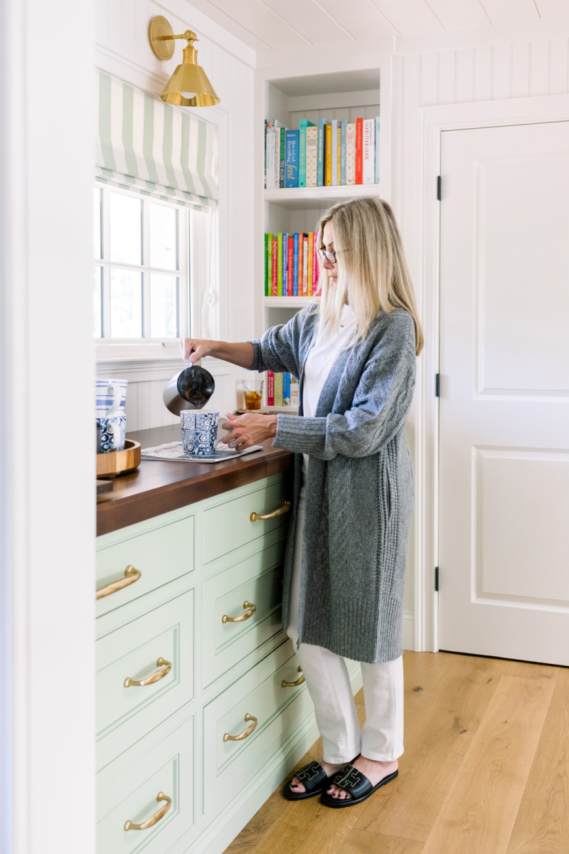 Woman in kitchen pouring coffee