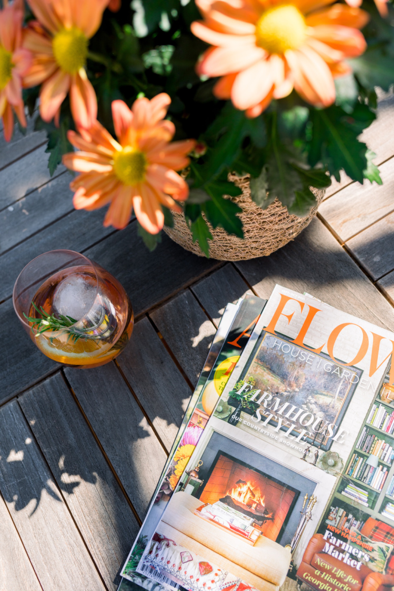 Wine glass flowers and magazines on teak table