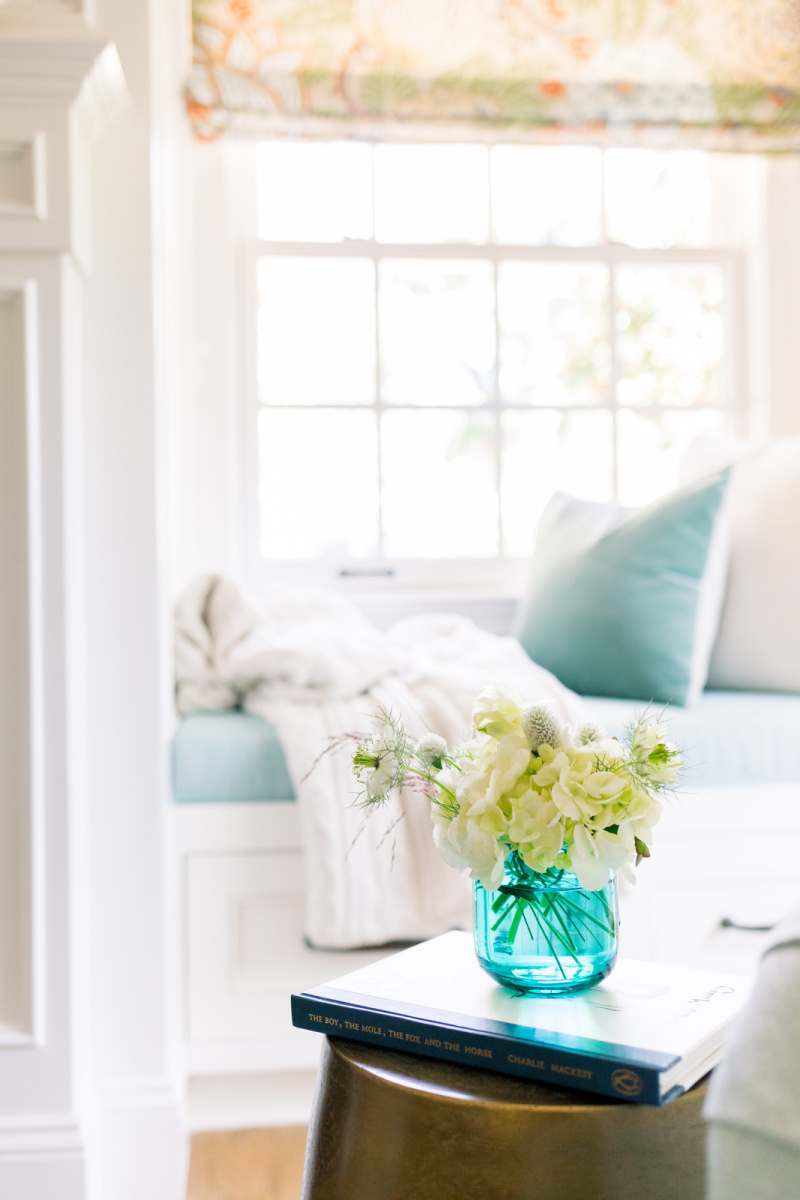 Window seat with throw and small flower arrangement