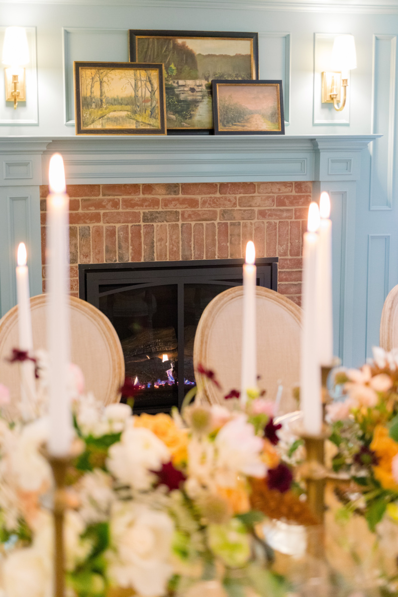 Candle sticks on table in front of fireplace