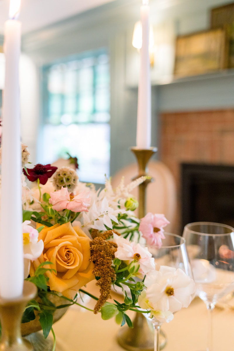 Candles and flowers beside fireplace