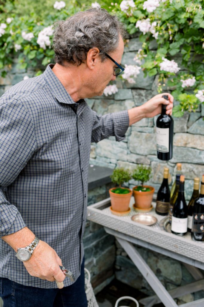 Man holding wine bottle on patio