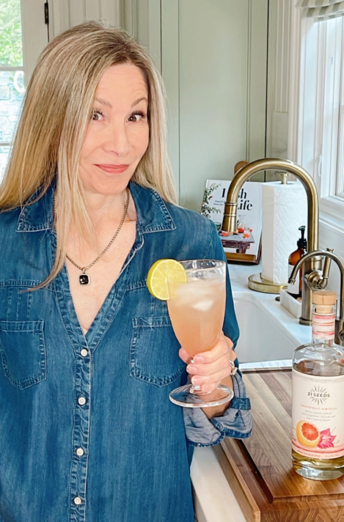 Woman holding Spritzer drink in kitchen