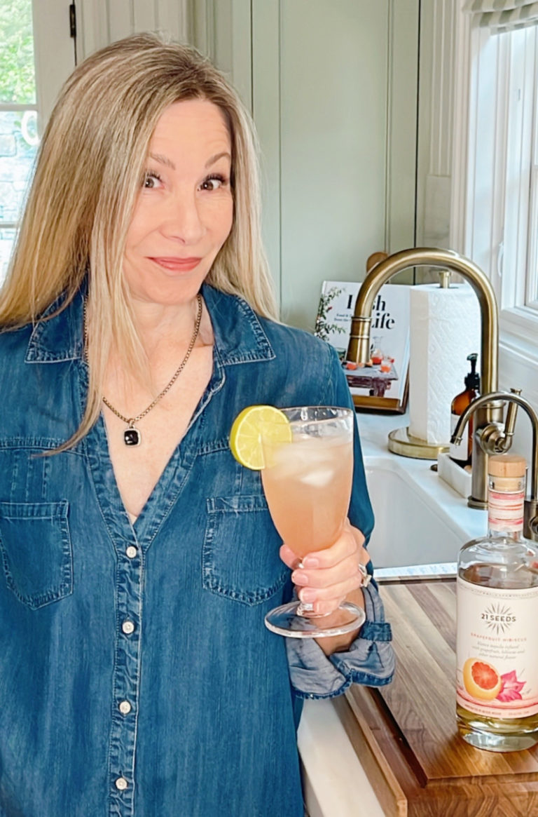 Woman holding Spritzer drink in kitchen
