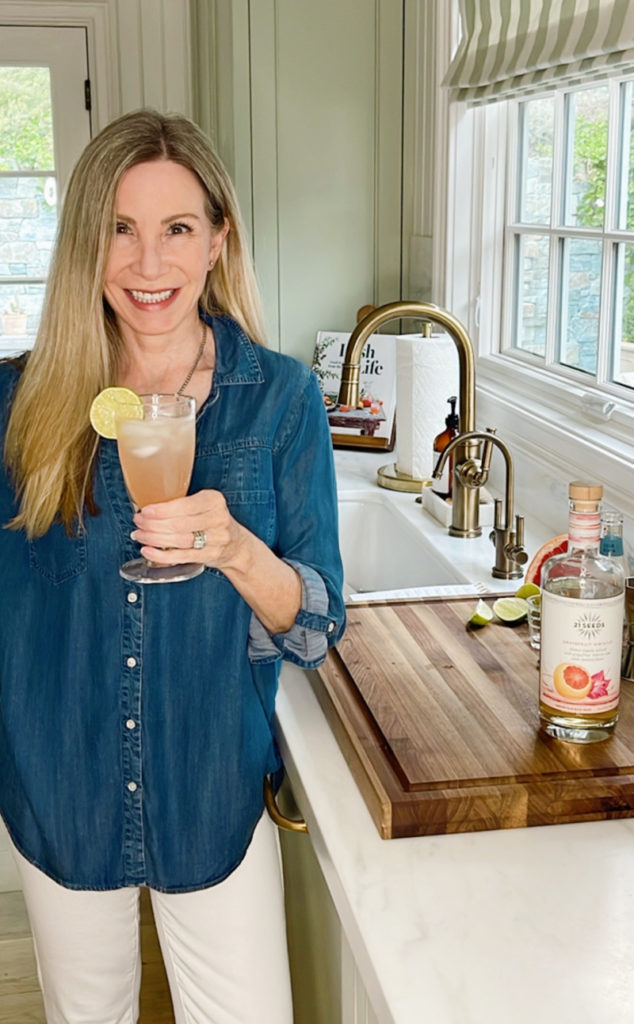Woman holding drink in kitchen