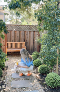 Woman with mimosa in garden with dog