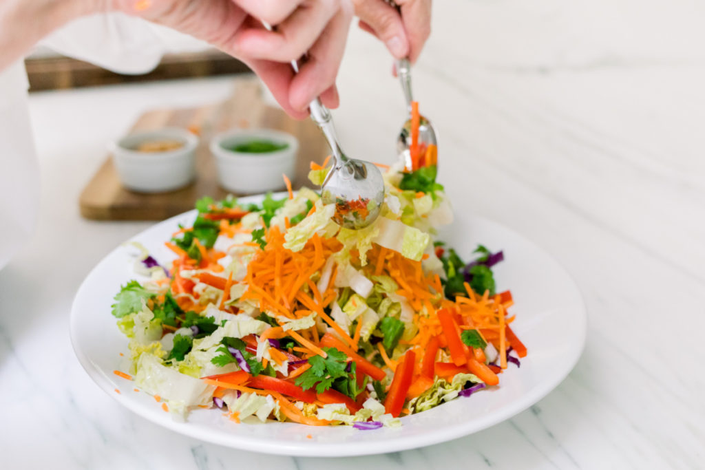 Asian Chicken Salad tossing in bowl
