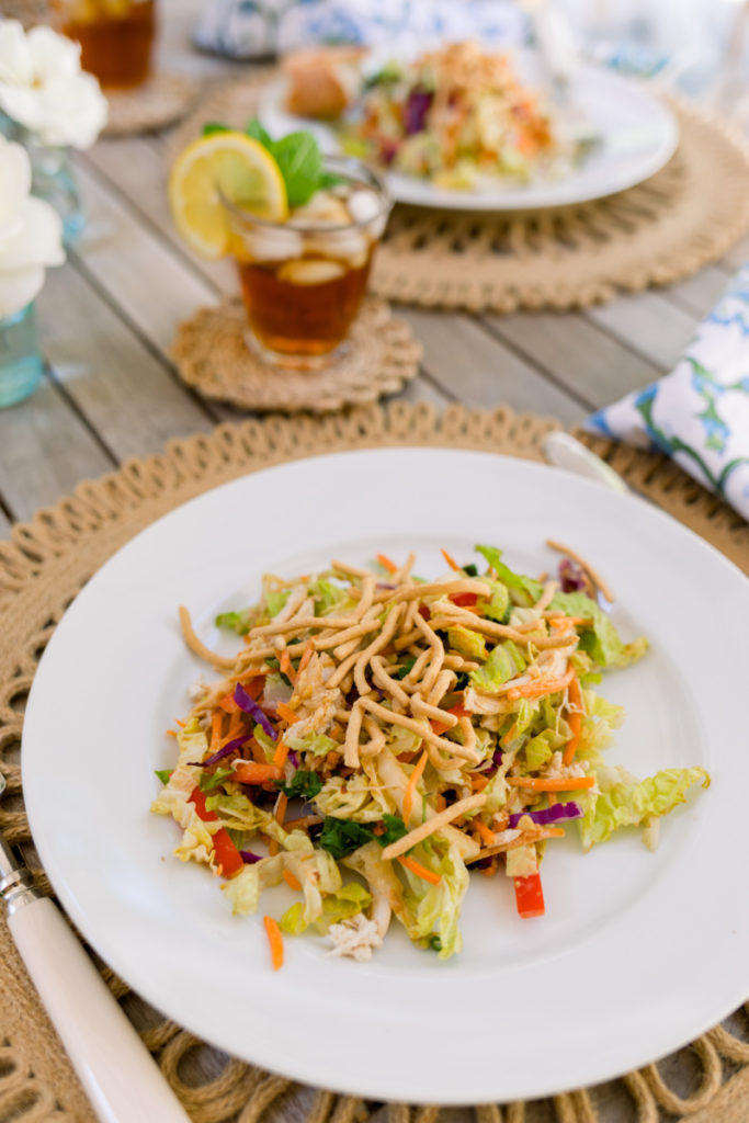 Serving of Asian chicken salad with ice tea outdoors