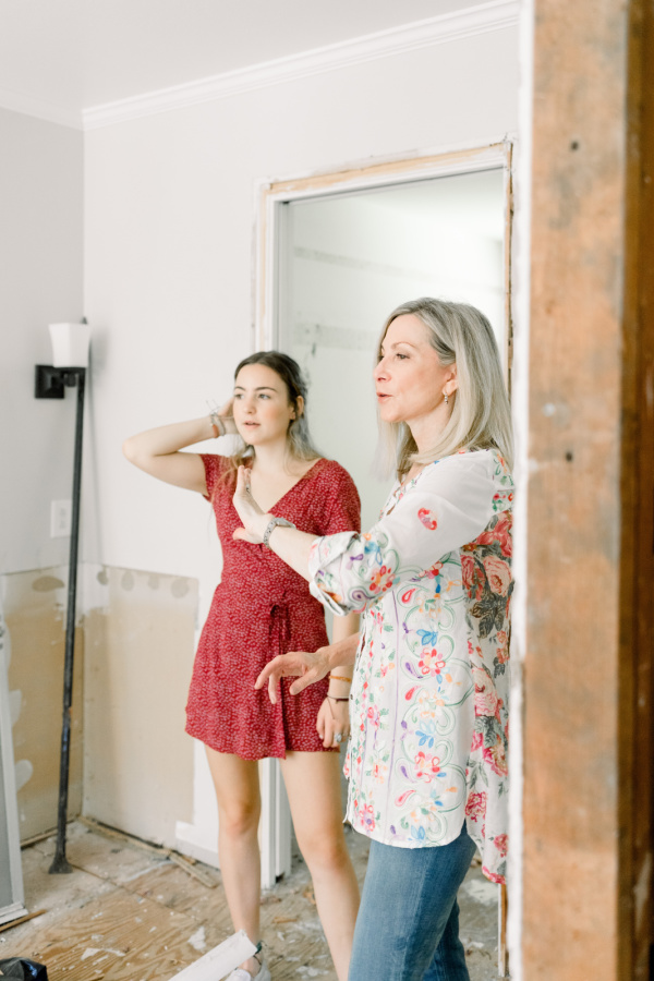 Two women standing in demo'd bathroom