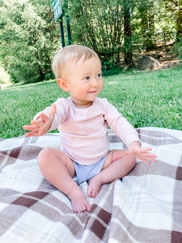 baby on blanket in park