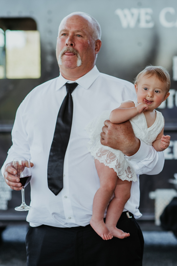 Grandpa holding baby at wedding