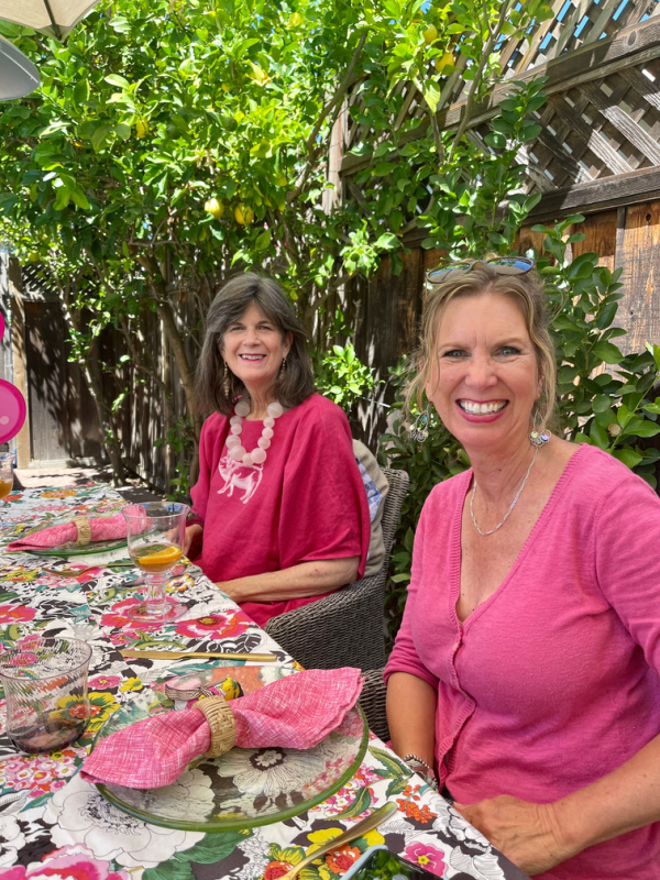Two women in pink at outdoor dining table