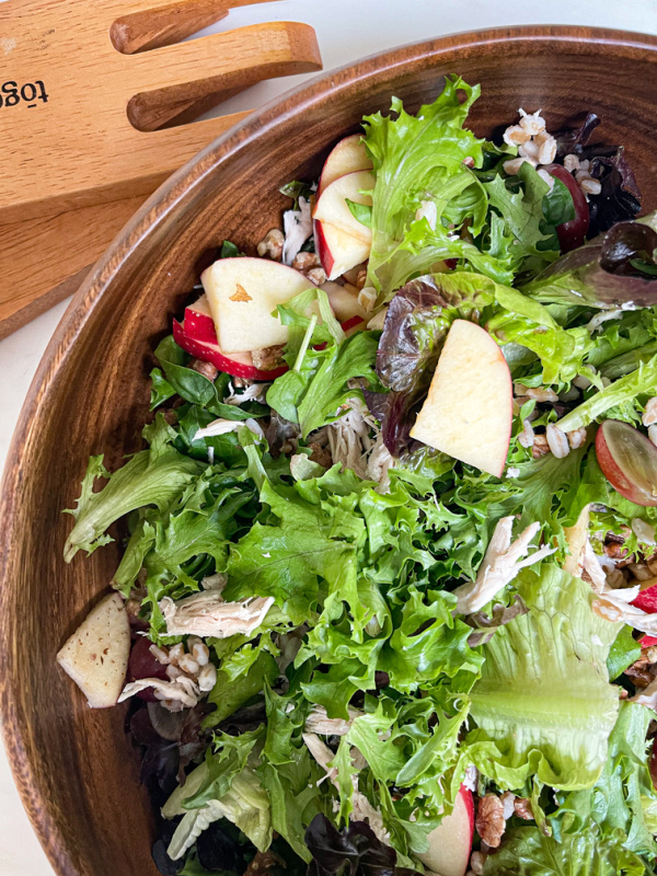 Bowl of salad with apples, grapes and walnuts.
