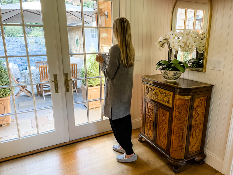 Woman holding mug looking out window.