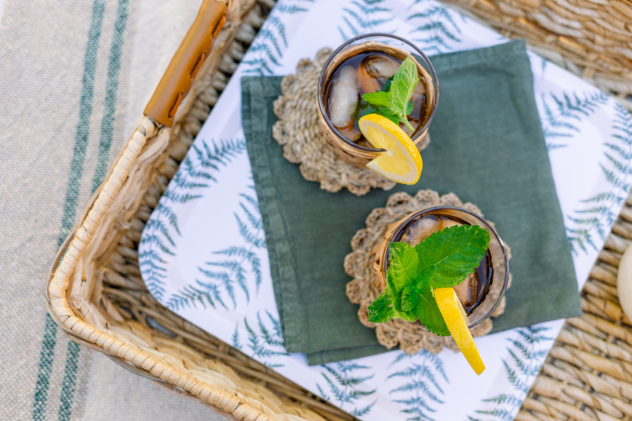 Two glasses of ice tea on woven tray.