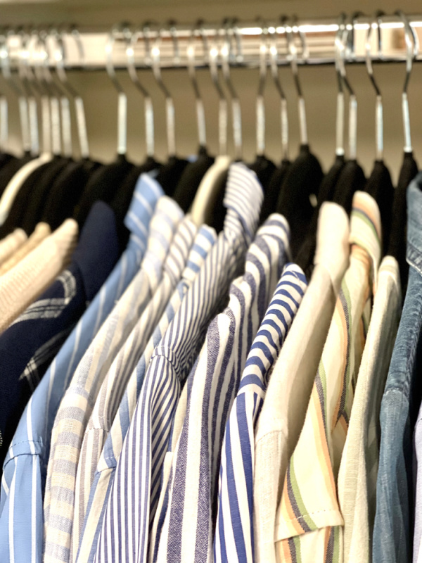 Striped shirts hanging in closet.