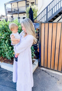 Woman holding baby in hotel patio.