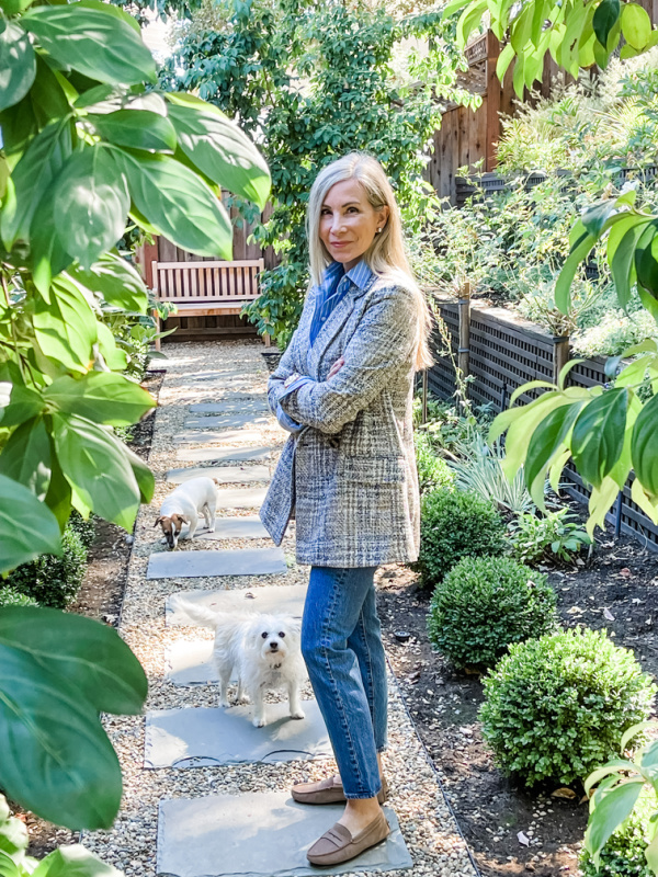 Woman standing in garden with little dogs.
