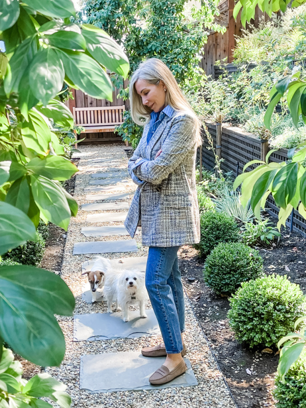 Woman standing in garden with dog.