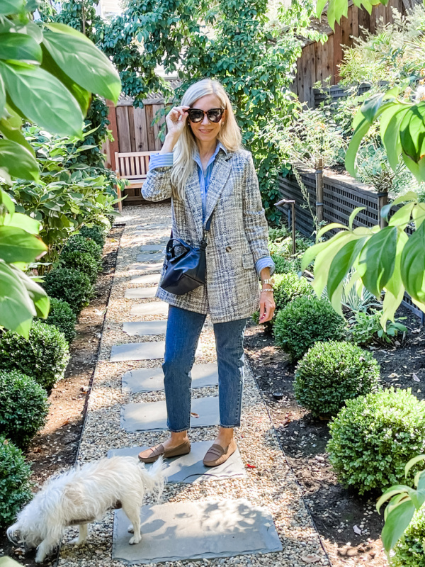 Woman standing in garden with dog.