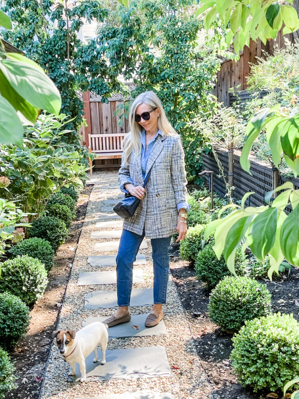 Woman standing in garden with little dog.