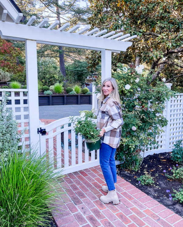 Woman in garden wearing plaid shacket from Amazon.