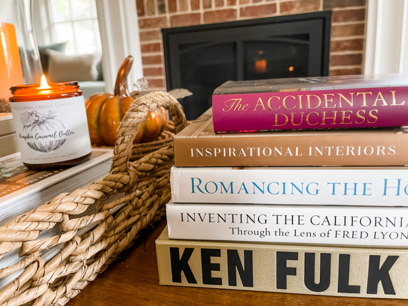 Stack of books on coffee table in from of fire.