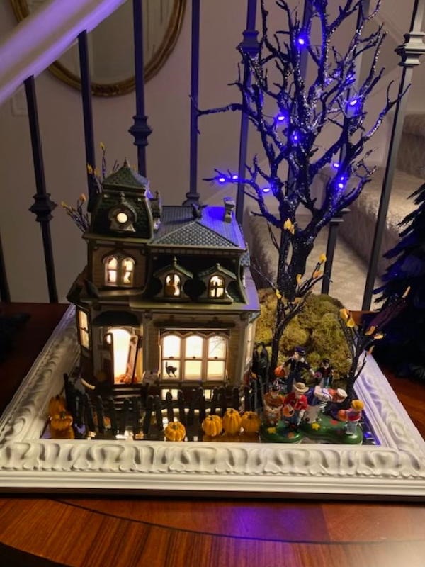 Haunted mansion vignette at night.