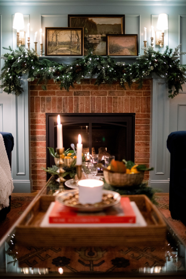 Coffee table decorated for Christmas and garland draped mantle.