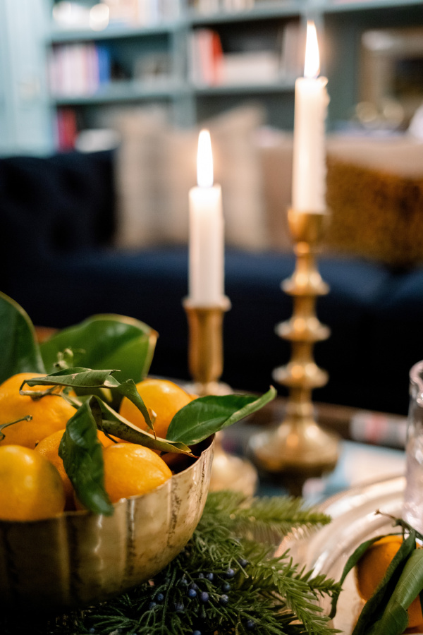 Brass candlesticks and a bowl of oranges in home library room.