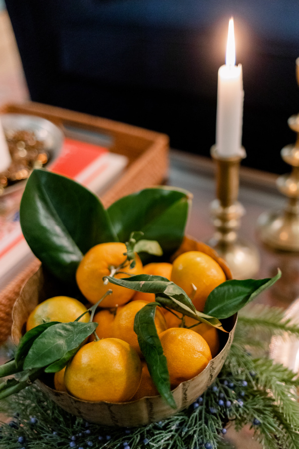 Aged brass compote dish filled with stemmed oranges.