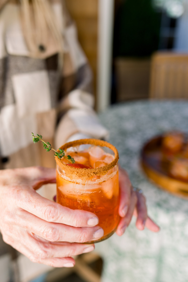 Woman holding Apple Cider Aperol Spritz.