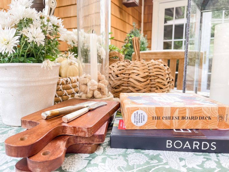 Outdoor fall table with cheese board and charcuterie books.