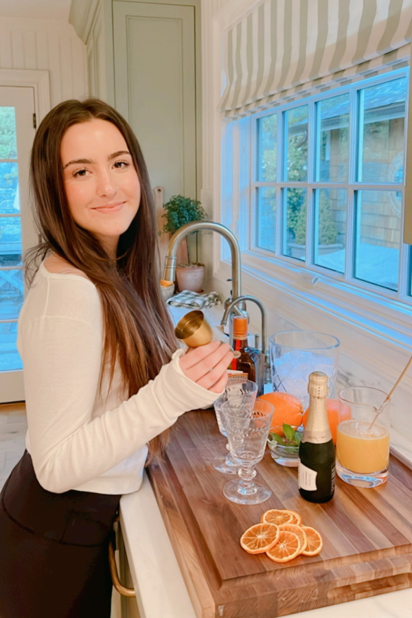 Woman in kitchen making a spritzer.
