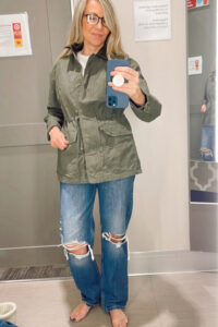 Woman trying on utility jacket in Target dressing room.