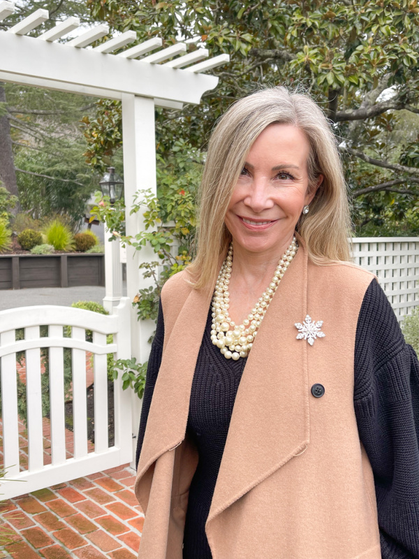 Woman outside wearing snowflake holiday pin.