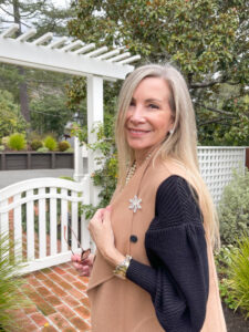 woman holding lapel to show off snowflake pin.