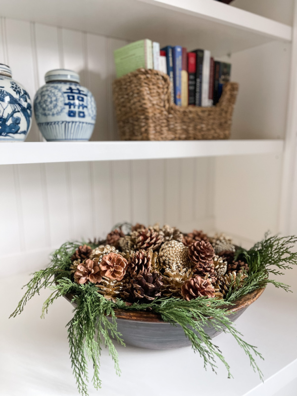 Bowl of greenery and pinecones.
