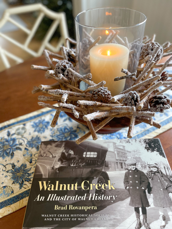 Holiday centerpiece on table runner with book.